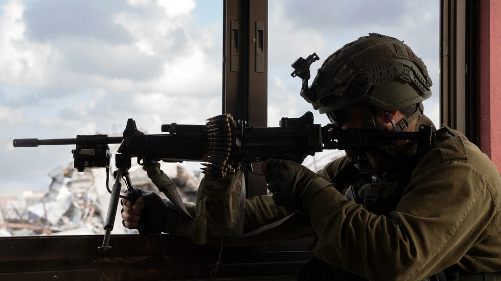 An Israeli soldier aims a machine gun in Gaza City in May 2024 (Israeli Army/AFP)
